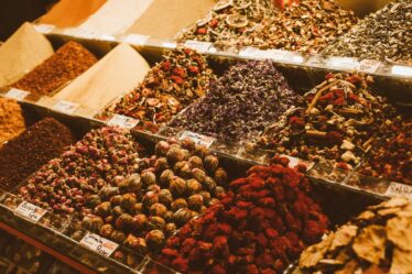 containers full of spices on a market stall