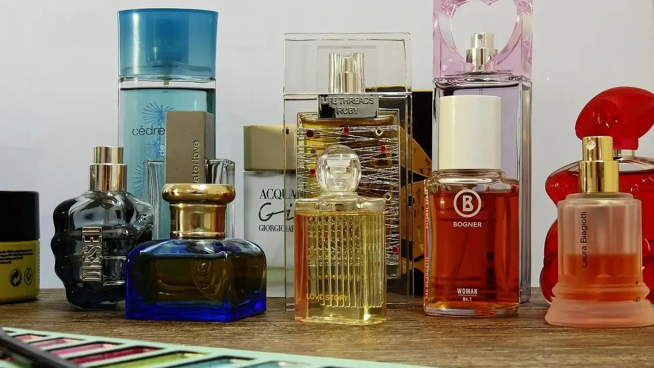 A table displaying an assortment of perfume bottles alongside various brushes for application and decoration.