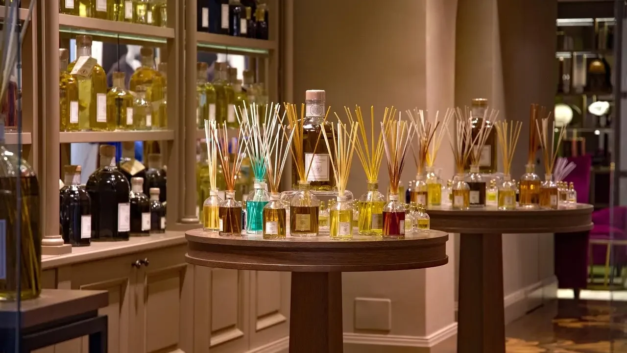 . A cozy room filled with various perfume bottles and scented candles arranged on shelves and tables.