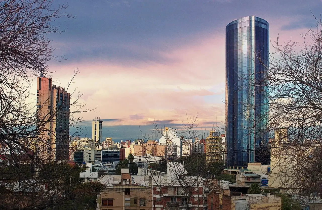 A city skyline featuring a tall building in Argentine prominently in the background against a clear blue sky.