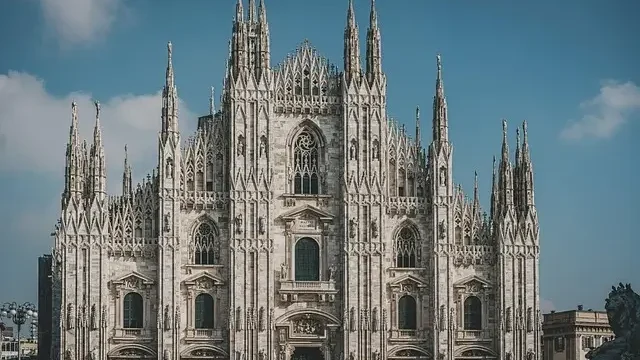 The Duomo in Milan, Italy, showcasing its intricate Gothic architecture and towering spires against a clear blue sky.