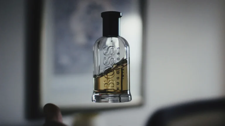 A person holding a bottle of liquor, showcasing the label and the bottle's shape in a casual setting.