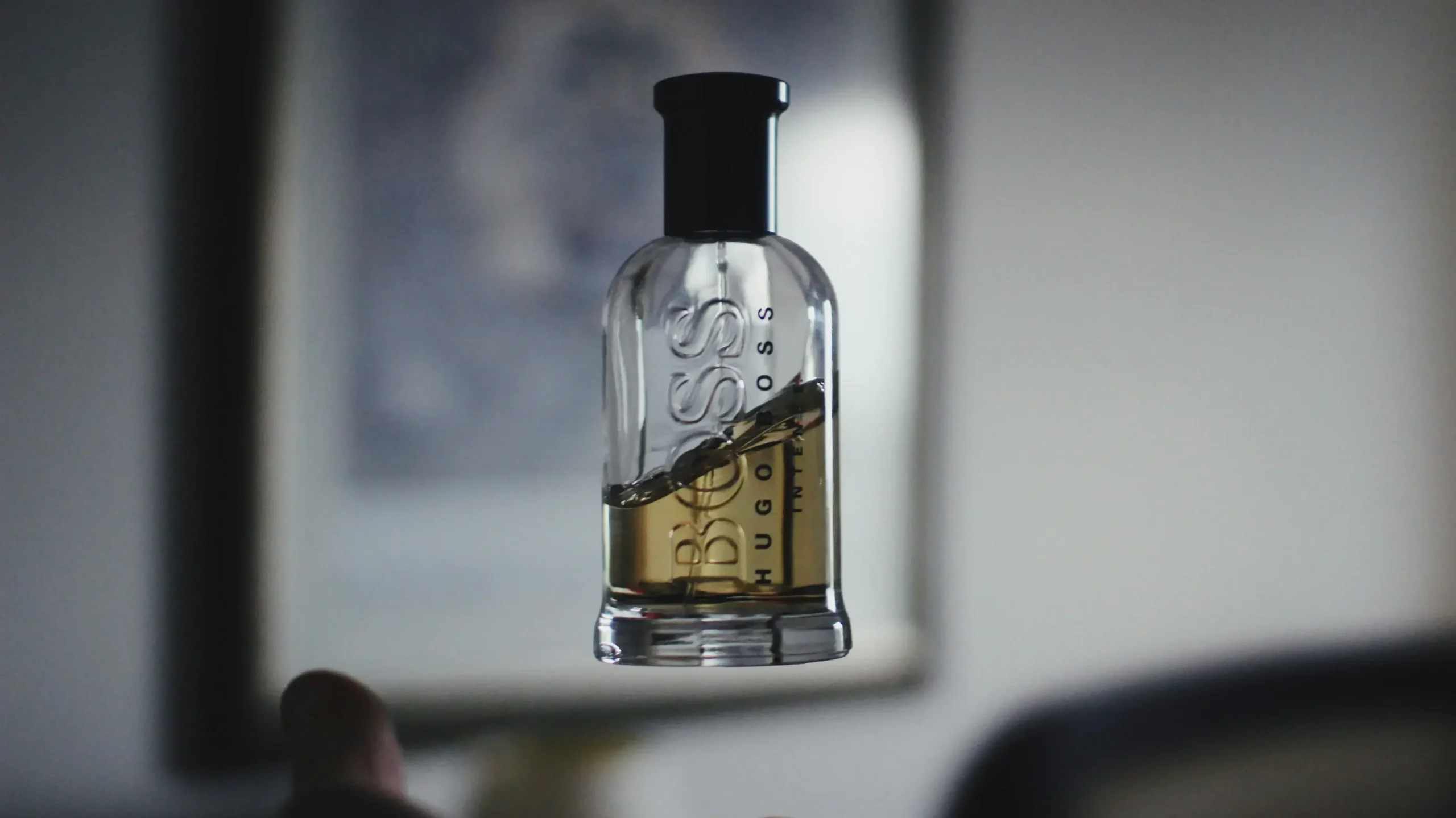 A person holding a bottle of liquor, showcasing the label and the bottle's shape in a casual setting.