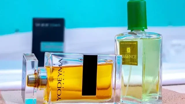 A bottle of perfume elegantly placed on a soft towel, showcasing its design and color against the fabric.