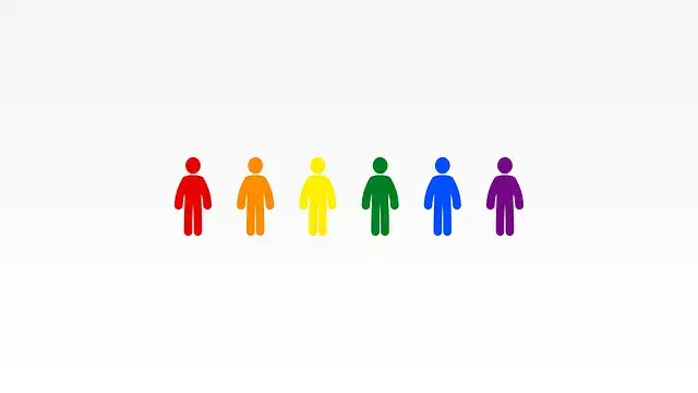 A diverse group of people in rainbow colors stands together against a plain white background