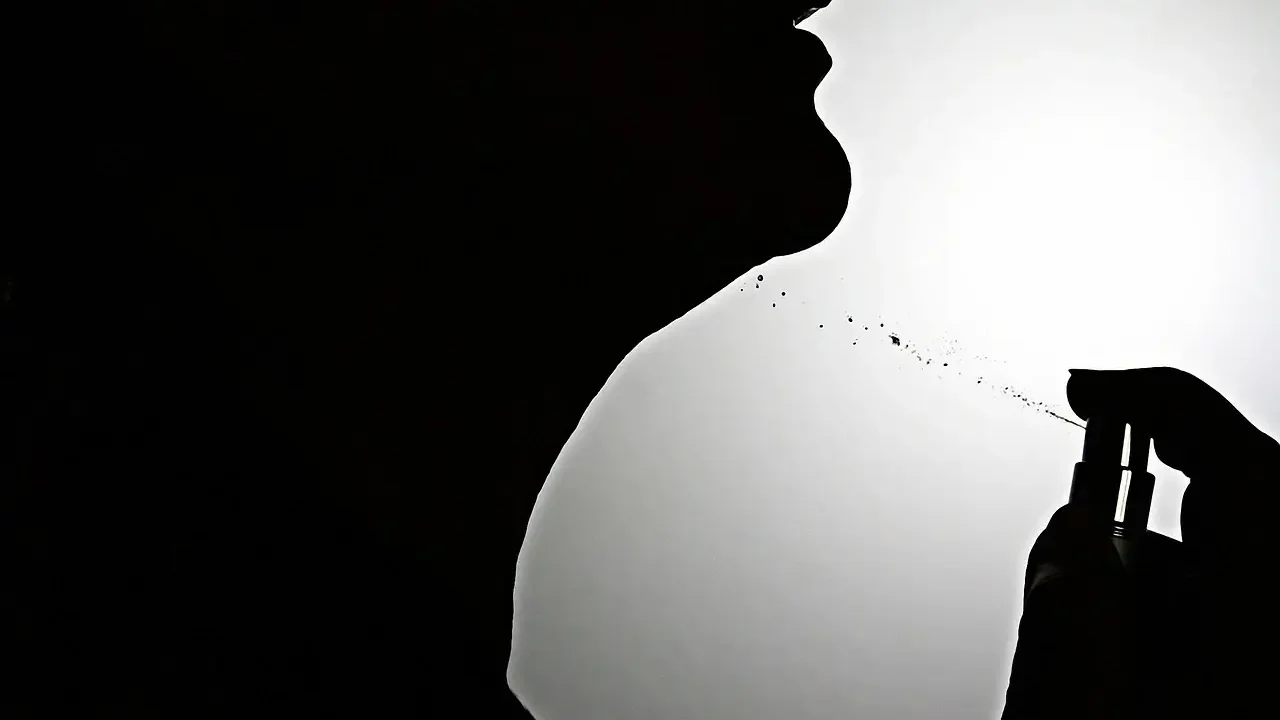 A woman is playfully blowing bubbles into her mouth, creating a whimsical and lighthearted scene.