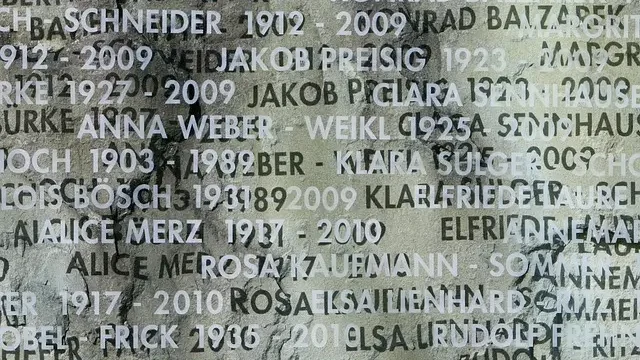 Names of war victims inscribed on a stone wall, honoring their memory and sacrifice