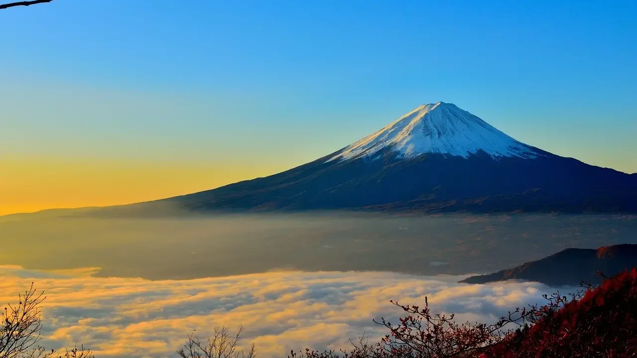 Mount Fuji, Japan's highest mountain, stands majestically with snow-capped peak against a clear blue sky