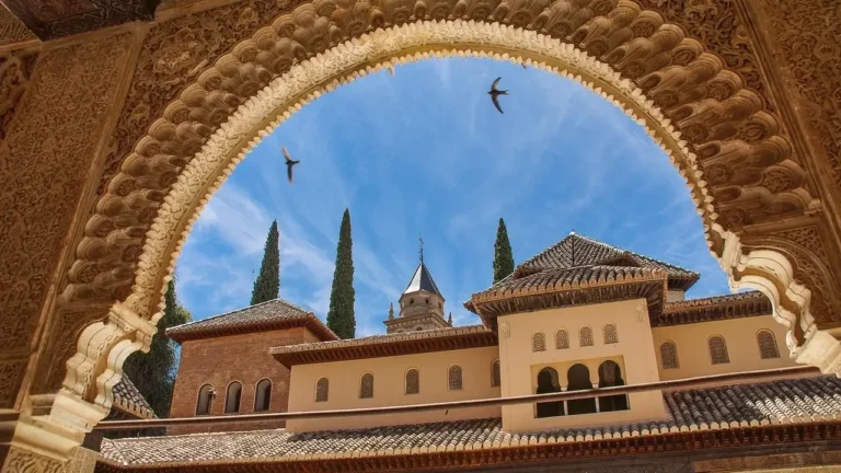 . The Alhambra, a historic palace and fortress in Granada, Spain, showcasing intricate Islamic architecture and lush gardens
