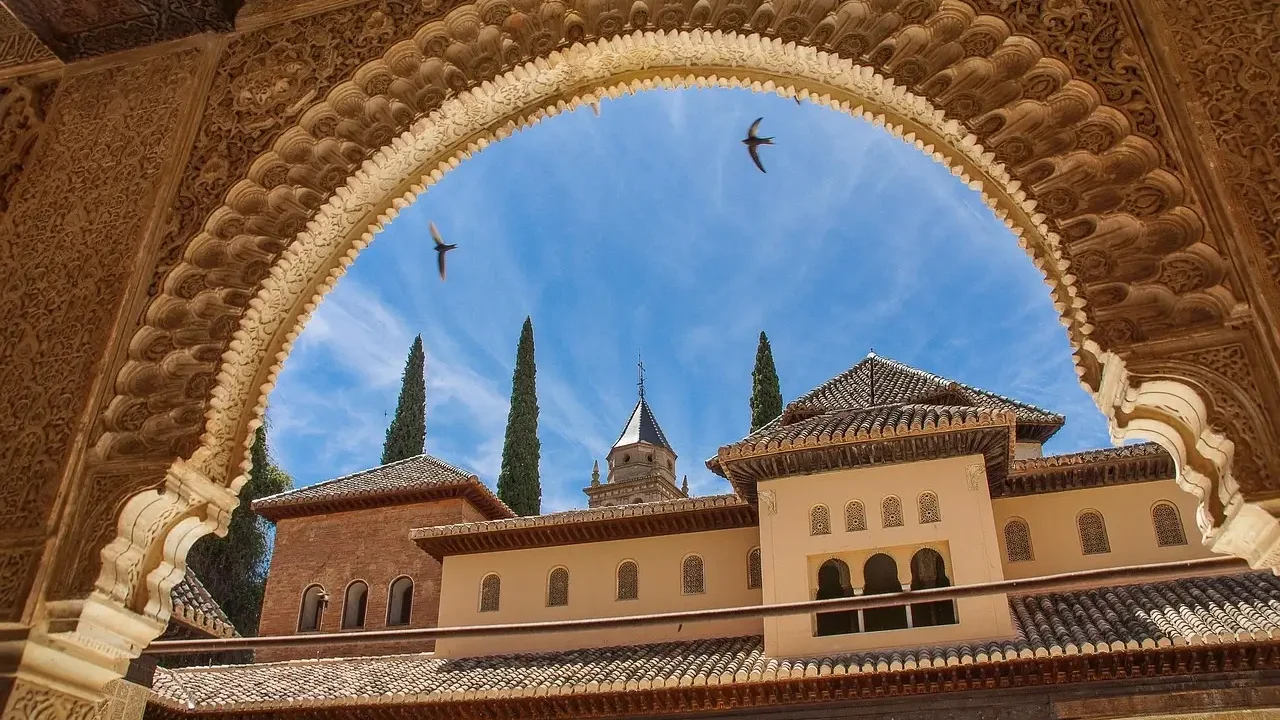 . The Alhambra, a historic palace and fortress in Granada, Spain, showcasing intricate Islamic architecture and lush gardens