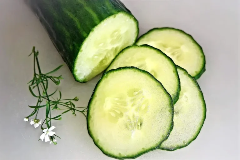 Cucumber slices arranged with colorful flowers on a clean white surface