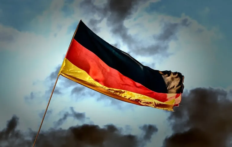 A German flag waving in the wind against a clear blue sky