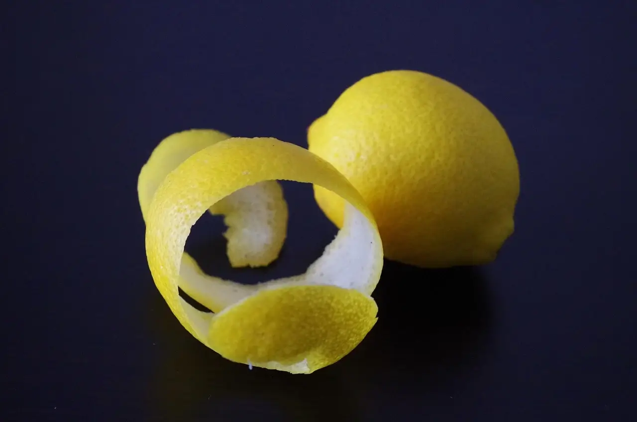 A lemon cut in half, with one half further sliced into two equal pieces, showcasing its juicy interior