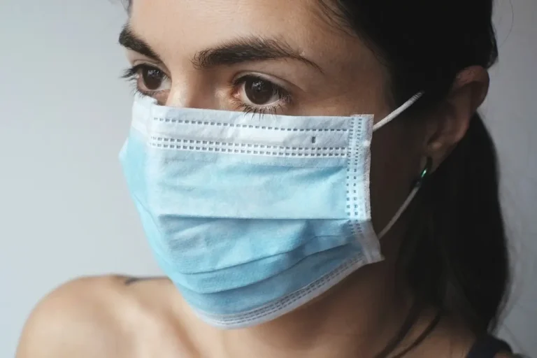 A woman wearing a surgical mask, emphasizing health and safety in a public setting