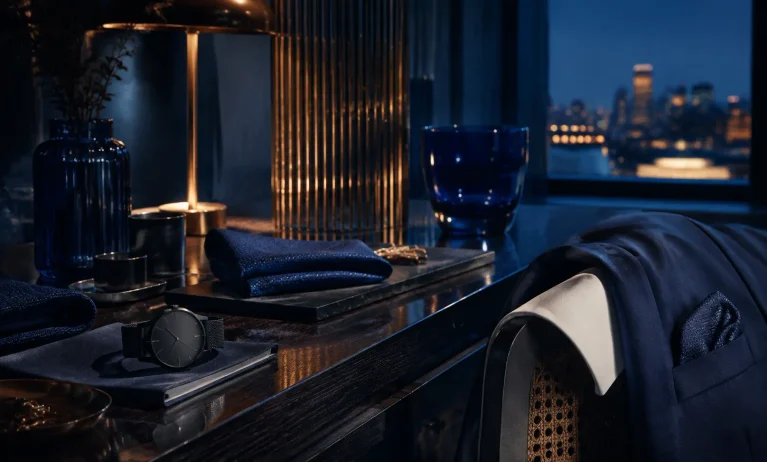 Elegant navy-blue lifestyle scene representing affordable Bleu de Chanel alternatives under $50, with tailored menswear, a watch, and refined dark-blue accessories.