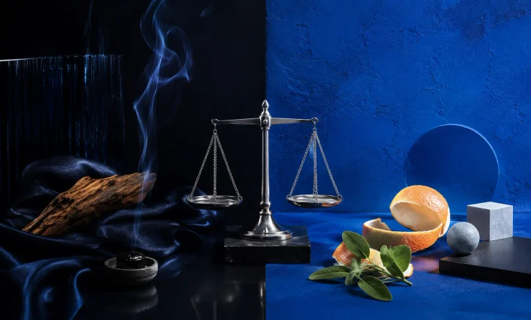 Luxury and affordable fragrance elements balanced on a scale, representing the choice between Bleu de Chanel and cheaper alternatives