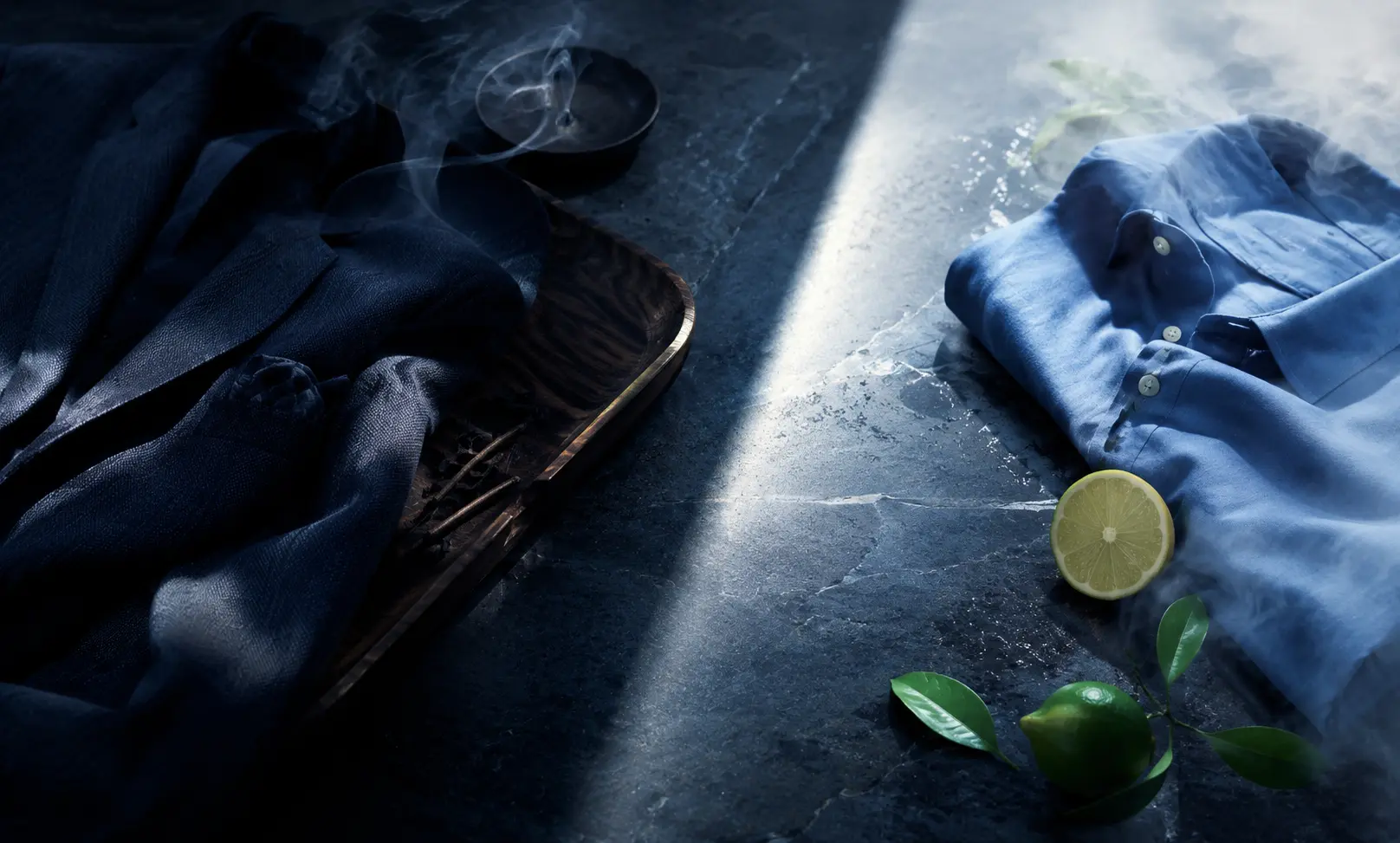 Cinematic comparison of Bleu de Chanel and Maison Alhambra Matière de Bleu through dark tailored fabric, blue textiles, citrus, woods, and contrasting light