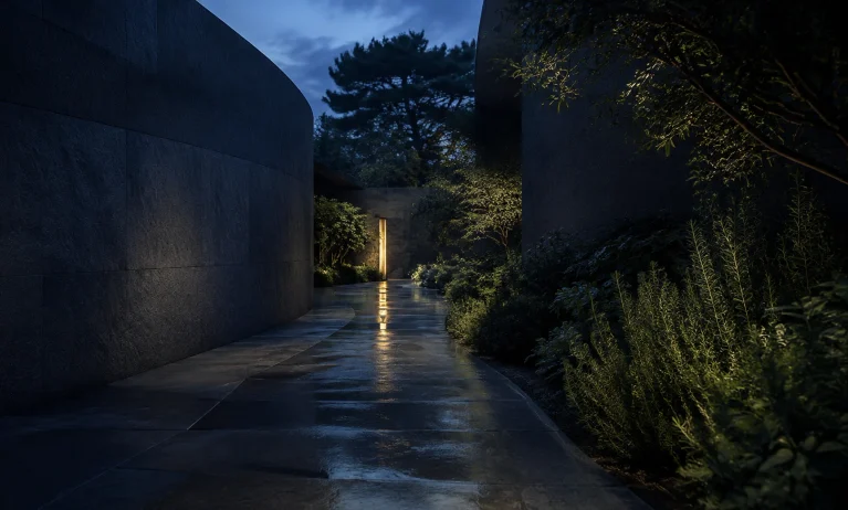 A quiet modern walkway at blue hour with deep navy stone, aromatic greenery, and warm light, representing distinctive less popular alternatives to Bleu de Chanel.